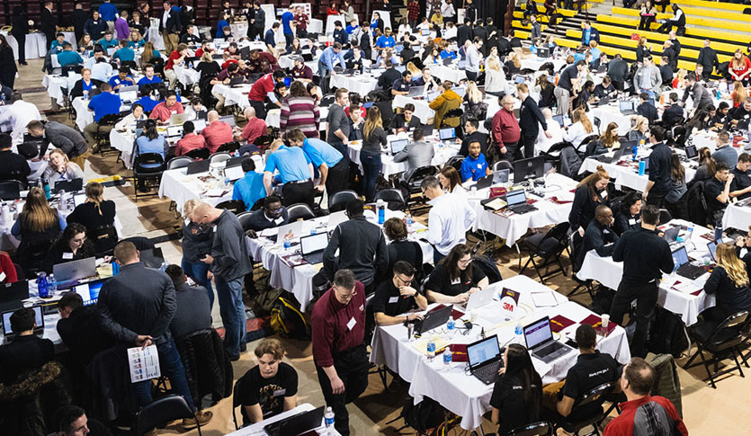 Students and mentors in McGuirk Arena competing in the ERPsim.